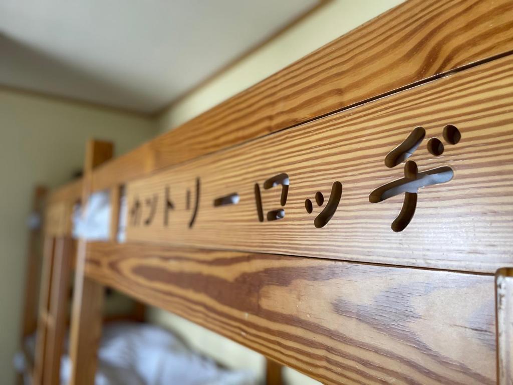 a row of wooden bunk beds with writing on them at NAEBA Country Lodge in Yuzawa