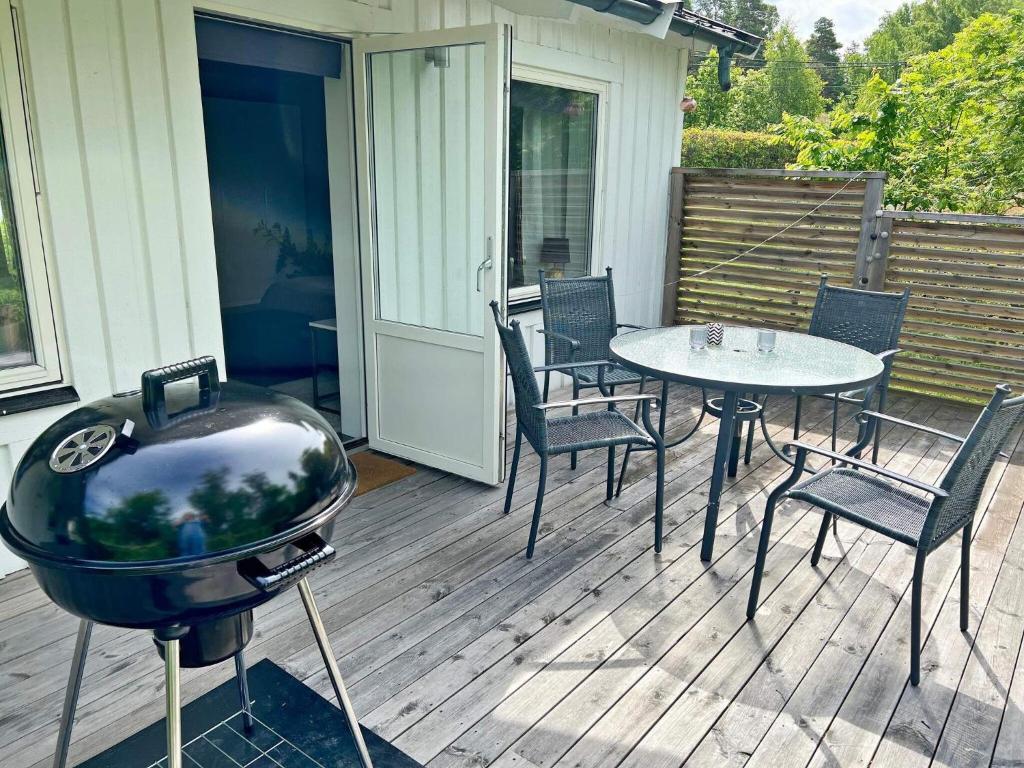 een grill op een terras met stoelen en een tafel bij Holiday home VÄRMDÖ V in Värmdö