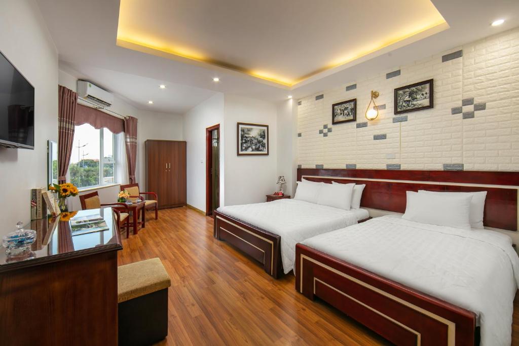 um quarto de hotel com duas camas e uma televisão em New Airport Hotel em Noi Bai