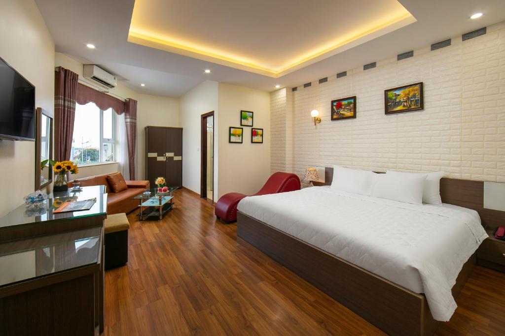 a hotel room with a bed and a living room at New Airport Hotel in Noi Bai