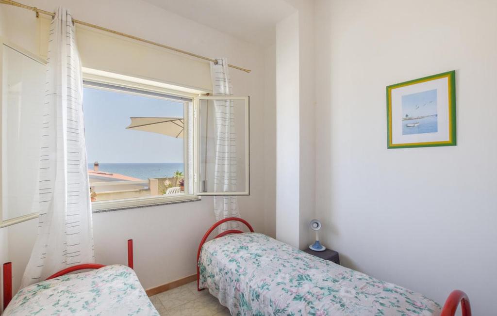 a bedroom with a window with a view of the ocean at Casa Aurora in Donnalucata