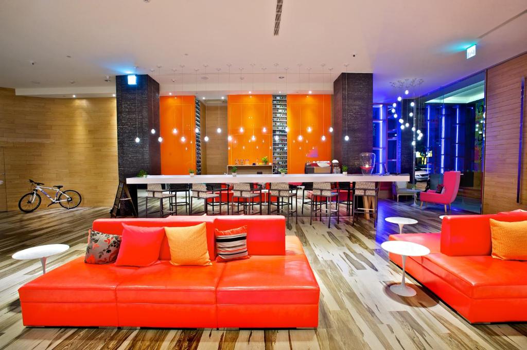 a lobby with an orange couch and a bar at FX INN Kaohsiung Zhonghua Road Branch in Kaohsiung