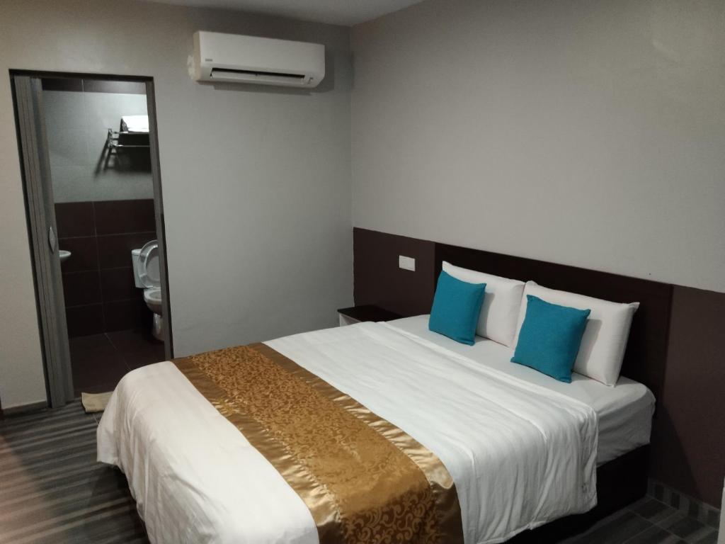ein Hotelzimmer mit einem großen Bett mit blauen Kissen in der Unterkunft One World Hotel in Kulai