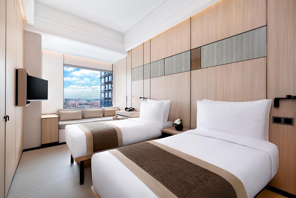 Postel nebo postele na pokoji v ubytování Harbour Plaza Metropolitan Shanghai
