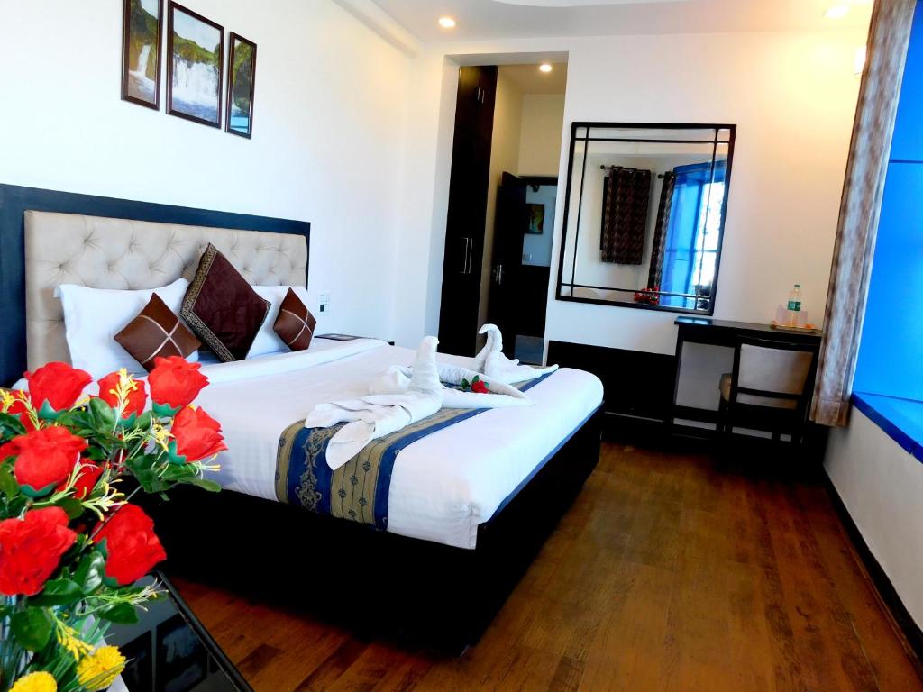 a hotel room with a bed and a mirror at Hotel Crystal Palace in Mussoorie