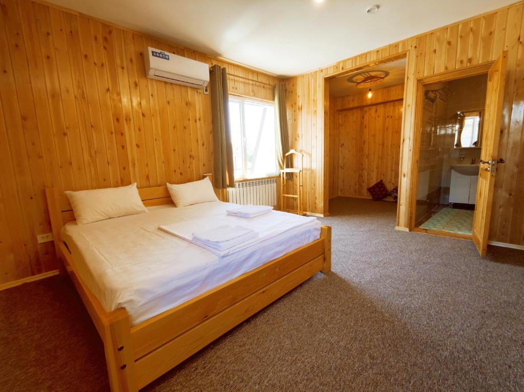 a bedroom with a large bed in a wooden room at SilkRoad Guesthouse in Bishkek