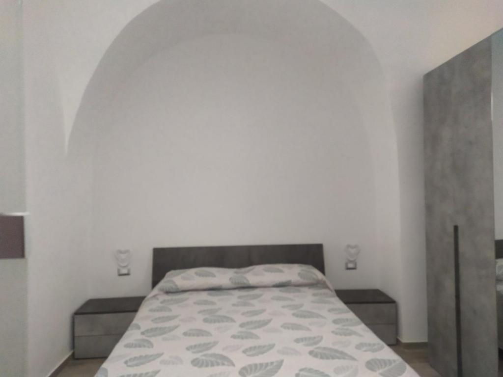 una camera da letto con un letto in una stanza bianca di Help a Santeramo in Colle