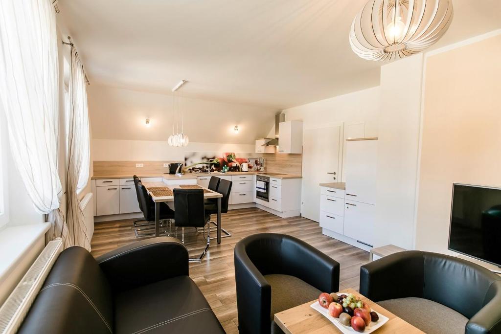 a kitchen and living room with a table and chairs at R&R Residenzen Ferienwohnungen in Mitterbach
