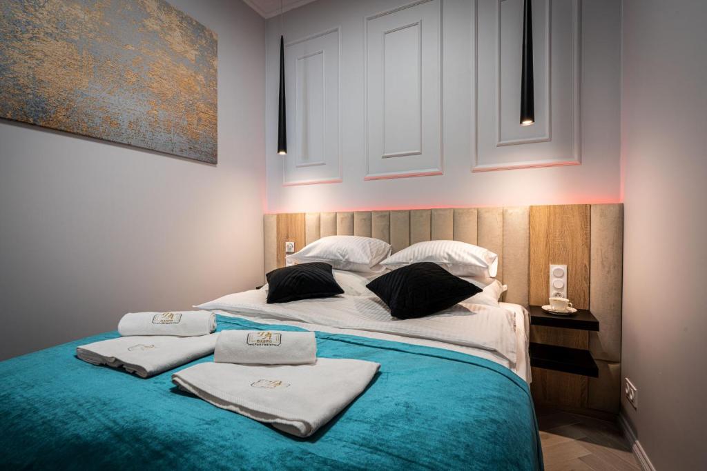sypialnia z łóżkiem z ręcznikami w obiekcie Dasto Apartments Old Town Kraków w Krakowie