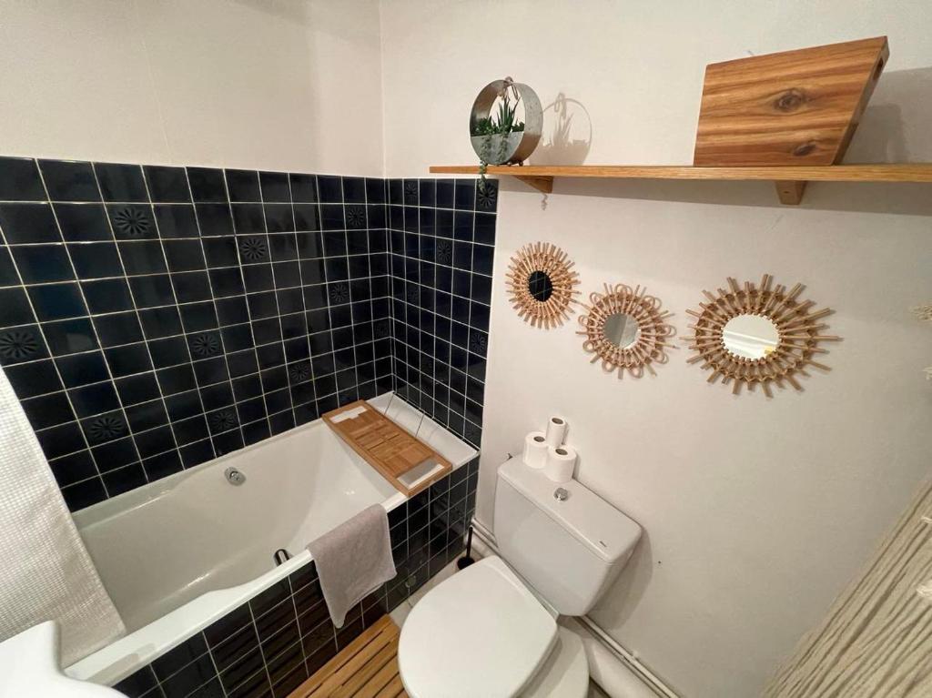 W łazience znajduje się toaleta, wanna i umywalka. w obiekcie Le Patio, coeur de ville avec garage et jardin w mieście Vannes