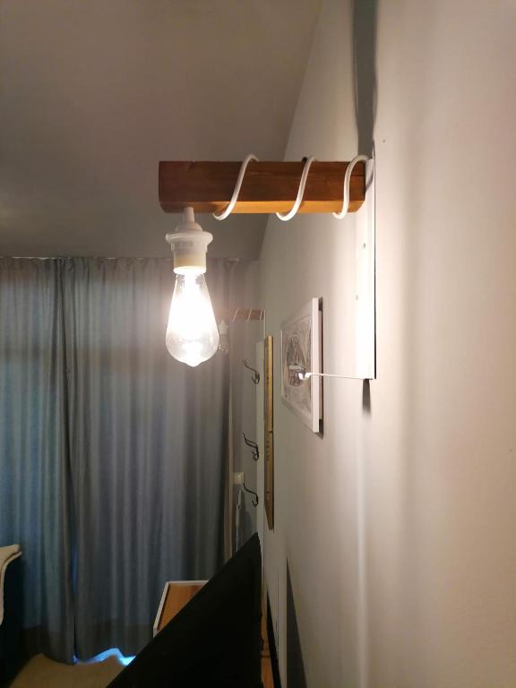 a light hanging from a wall next to a refrigerator at Casa do Farol - апартамент с басейн до плажа на къмпинг "Градина" in Chernomorets