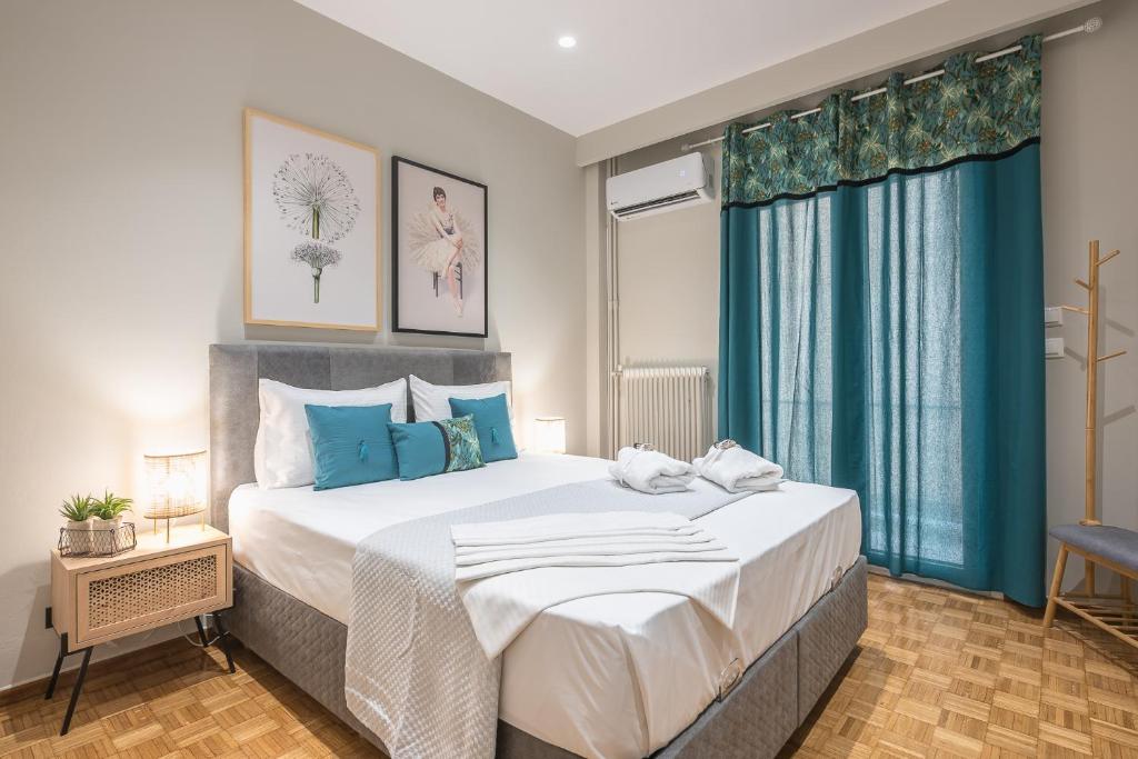um quarto com uma cama grande e cortinas azuis em Elegant Mavili Suite by CloudKeys em Atenas