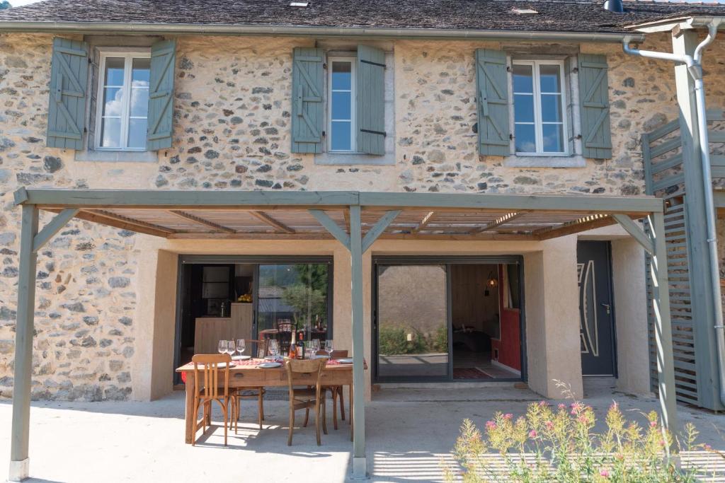 a wooden pergola in front of a house at La BERGERIE DE BELESTEN in Béon