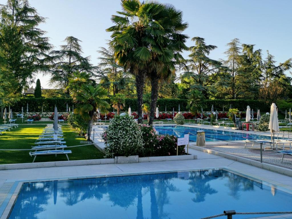 una piscina in un resort con palme di Best Western Plus Hotel Modena Resort a Formigine