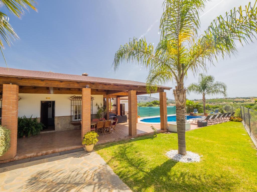 dom z palmą w ogrodzie w obiekcie Cubo's Villa Teresa w mieście Alhaurín el Grande