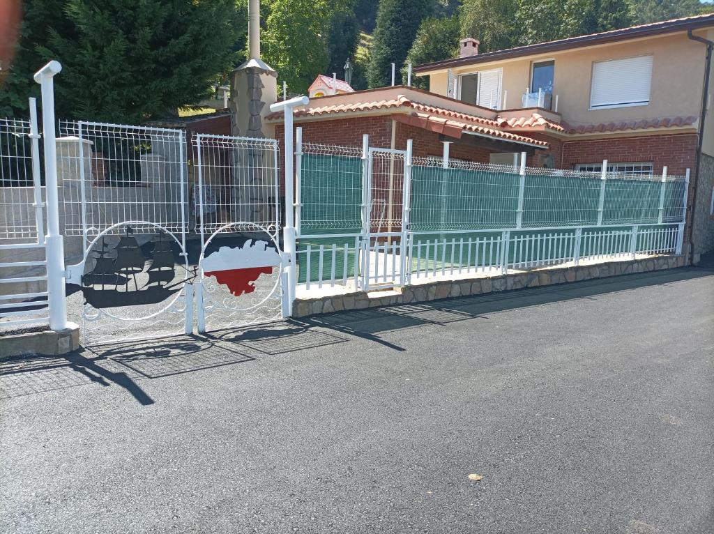 uma cerca branca em frente a uma casa em Casa Cabárceno em Santiago