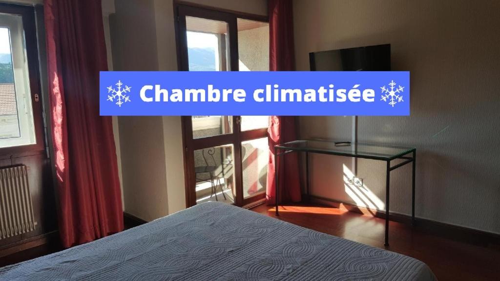 sypialnia z łóżkiem i znakiem, który czyta klimat klimatu w obiekcie Hotel De La Gare w Aix-les-Bains