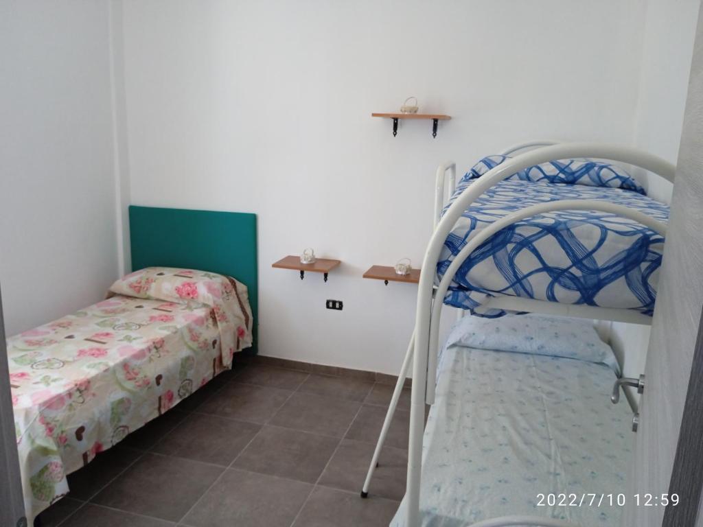 1 dormitorio con 2 literas y 1 cama en Villa rizzieddru, en Galatone