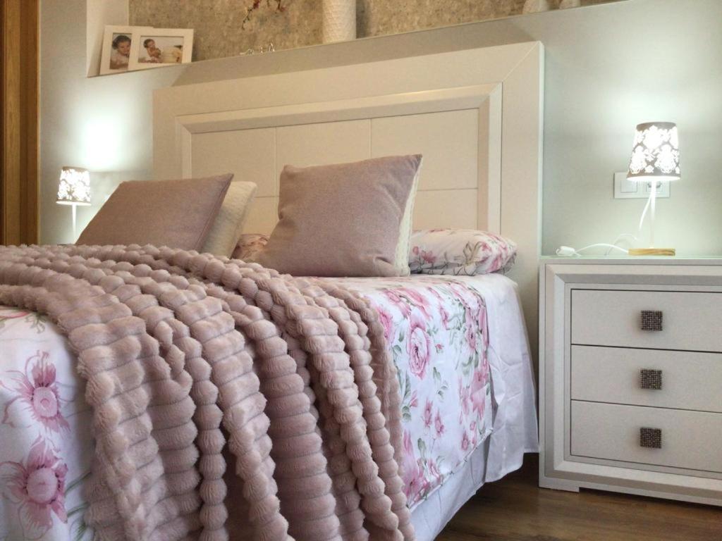een bed met een roze deken en een wit dressoir bij HyP - La Casa de Noa in Arcade