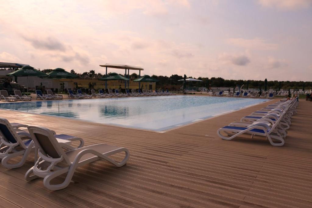 einen Pool mit Liegestühlen auf einer Terrasse in der Unterkunft Mediterranean Apartments at Blaxy, Olimp in Olimp