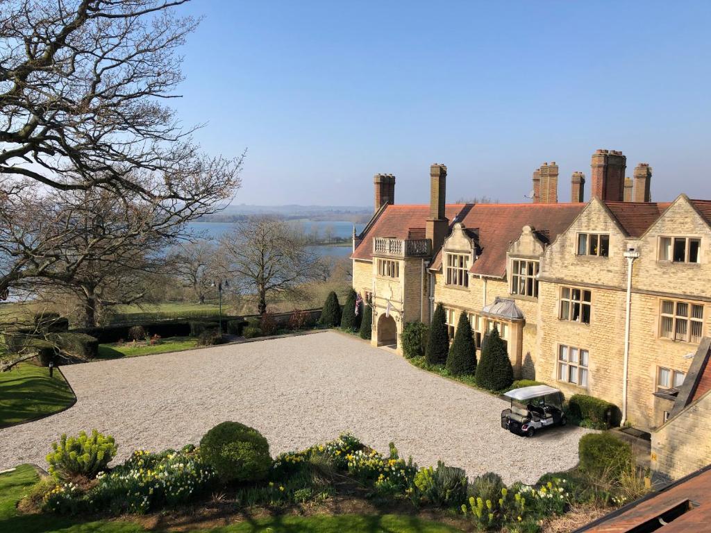 a large house with a car parked in the driveway at Rutland Hall Hotel in Oakham