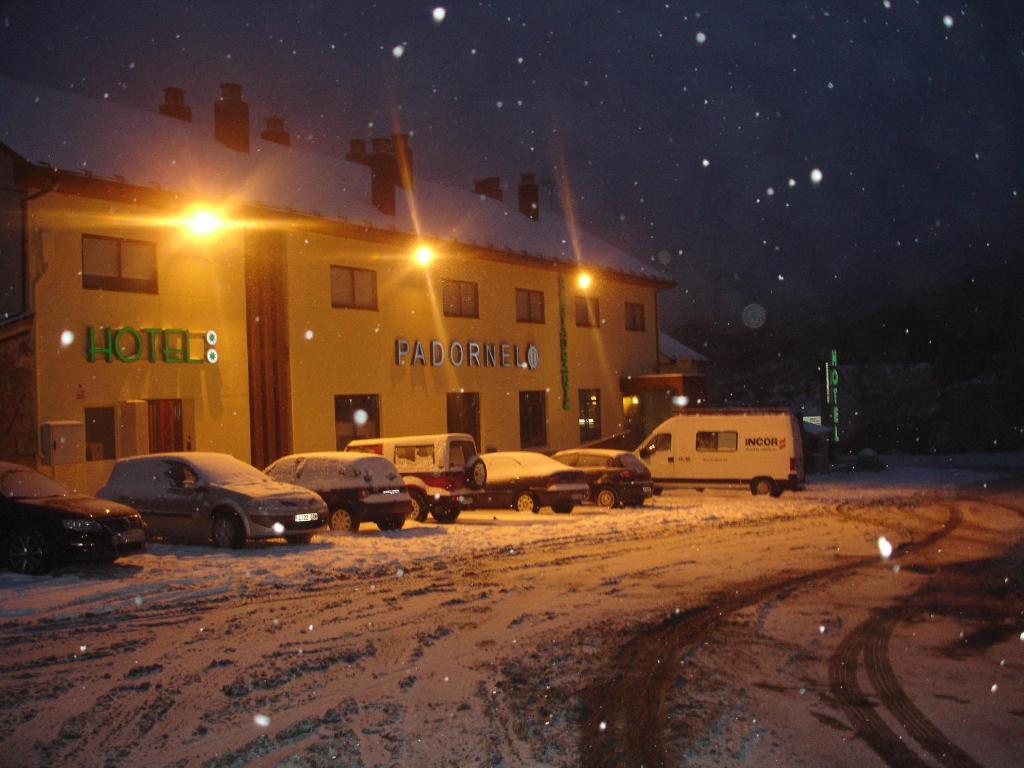 een groep auto's geparkeerd op een parkeerplaats in de sneeuw bij HOTEL RST. PADORNELO 