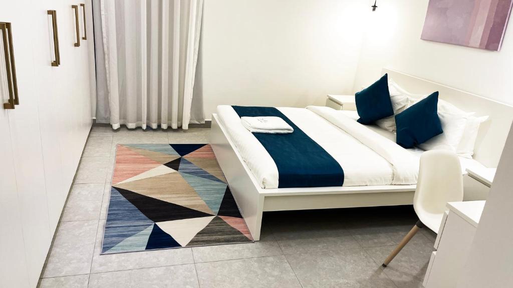 1 dormitorio con 1 cama con alfombra geométrica en Terminal Inn By Edar City Centre en Doha