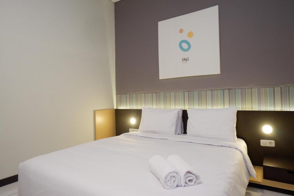 Postel nebo postele na pokoji v ubytování Sans Hotel Good Wish Semarang