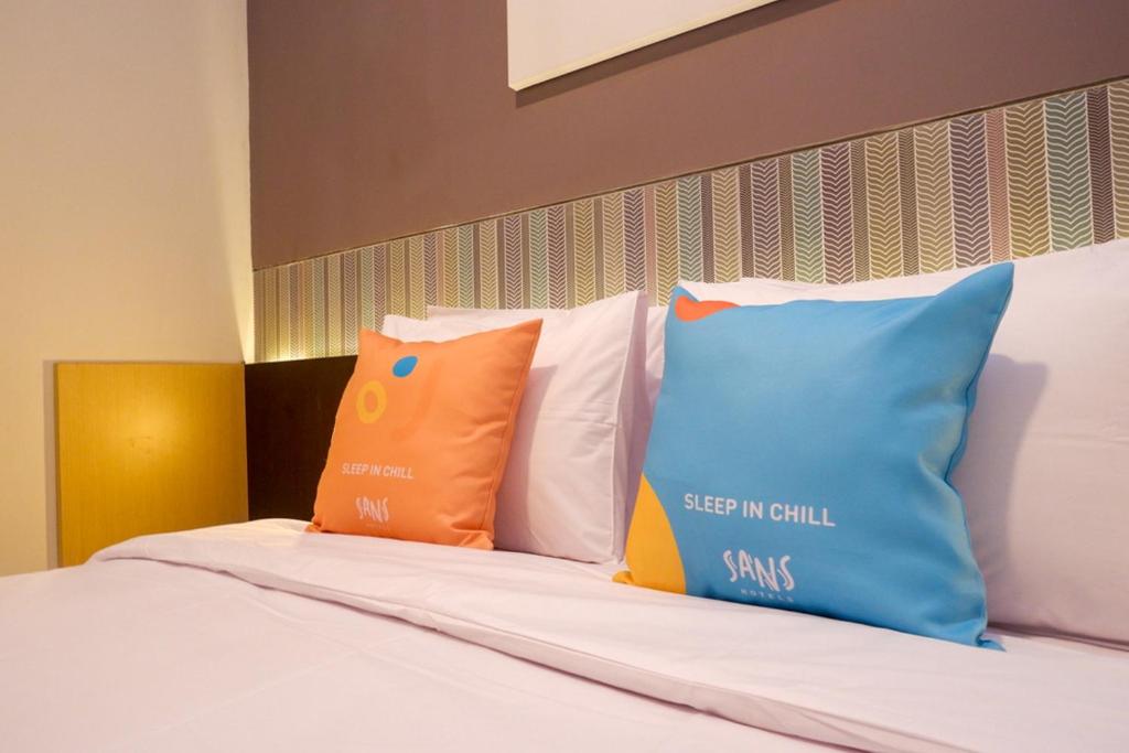 Postel nebo postele na pokoji v ubytování Sans Hotel Good Wish Semarang