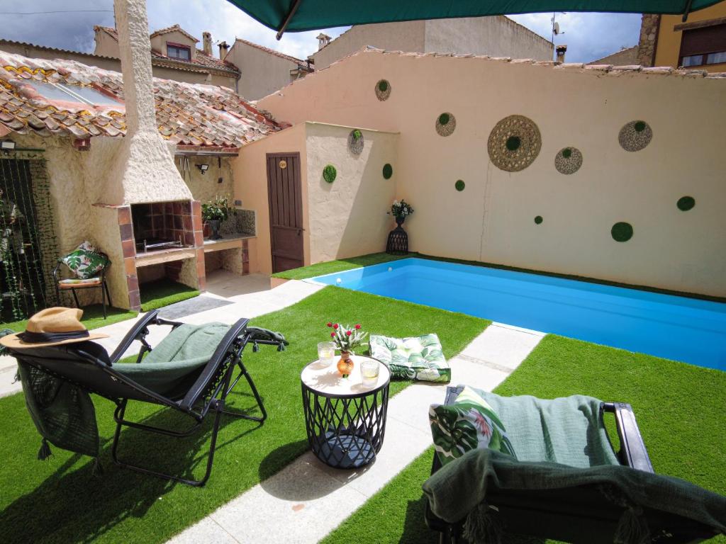 un patio trasero con piscina y una casa en El Pajar de Trescasas en Sonsoto