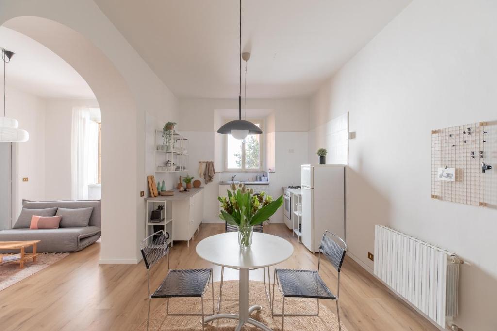 uma cozinha e sala de estar com mesa e cadeiras em iFlat Colosseo Modern Apartment em Rudiano