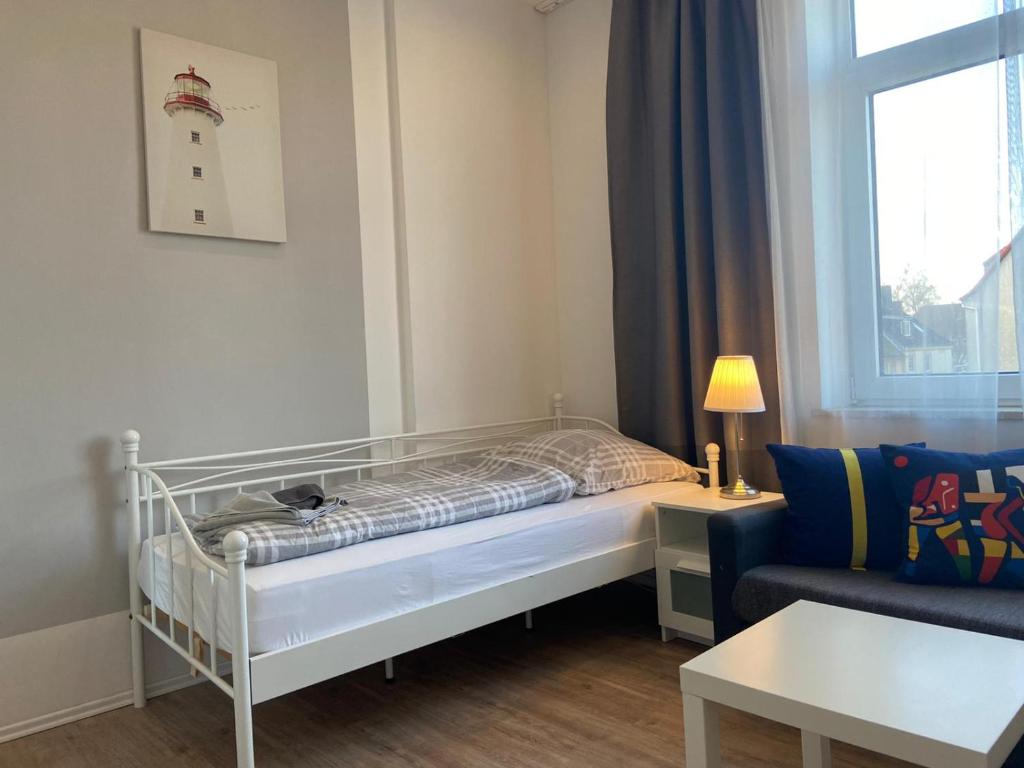 a small room with a bed and a couch at Apartment KENNEDY in Bremerhaven
