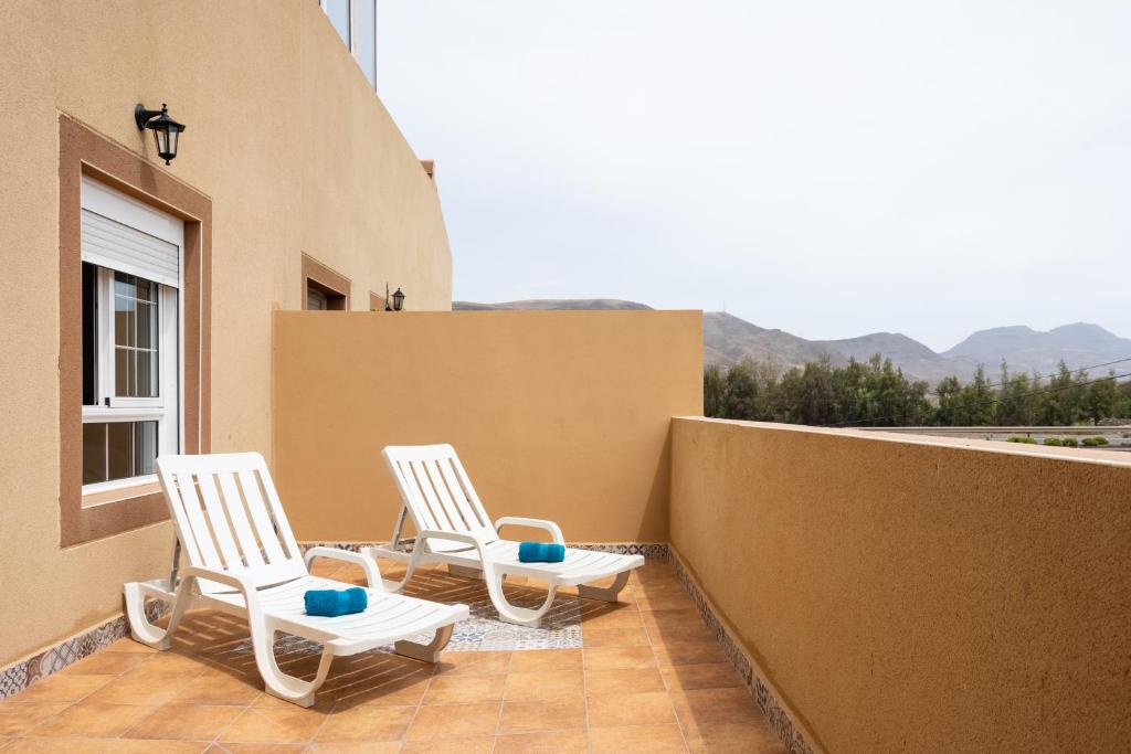 - deux chaises blanches sur un balcon avec vue dans l'établissement Home2Book Cozy Apartment La Lajita, à Lajita
