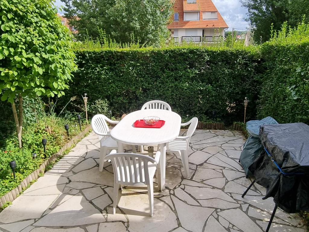 ヴィレ・シュル・メールにあるRésidence Le Franceの石造りのパティオ(白いテーブルと椅子付)