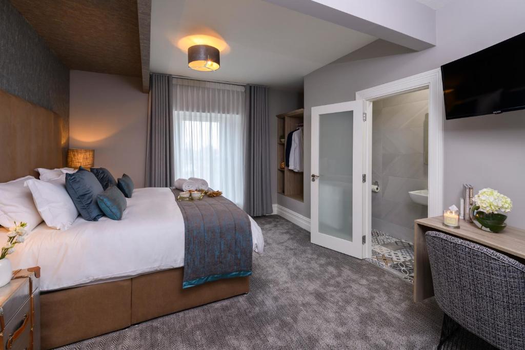 um quarto de hotel com uma cama grande e uma televisão em Maple Valley Guesthouse em Limerick