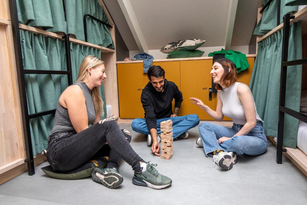 a group of people sitting on the floor in a room at The Bee Hostel in Amsterdam