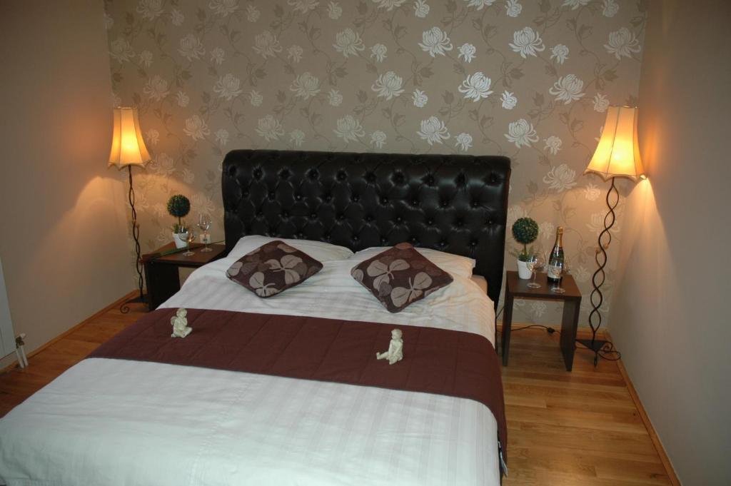 1 dormitorio con 1 cama grande y 2 mesitas de noche en Guest House Maja, en Novi Sad