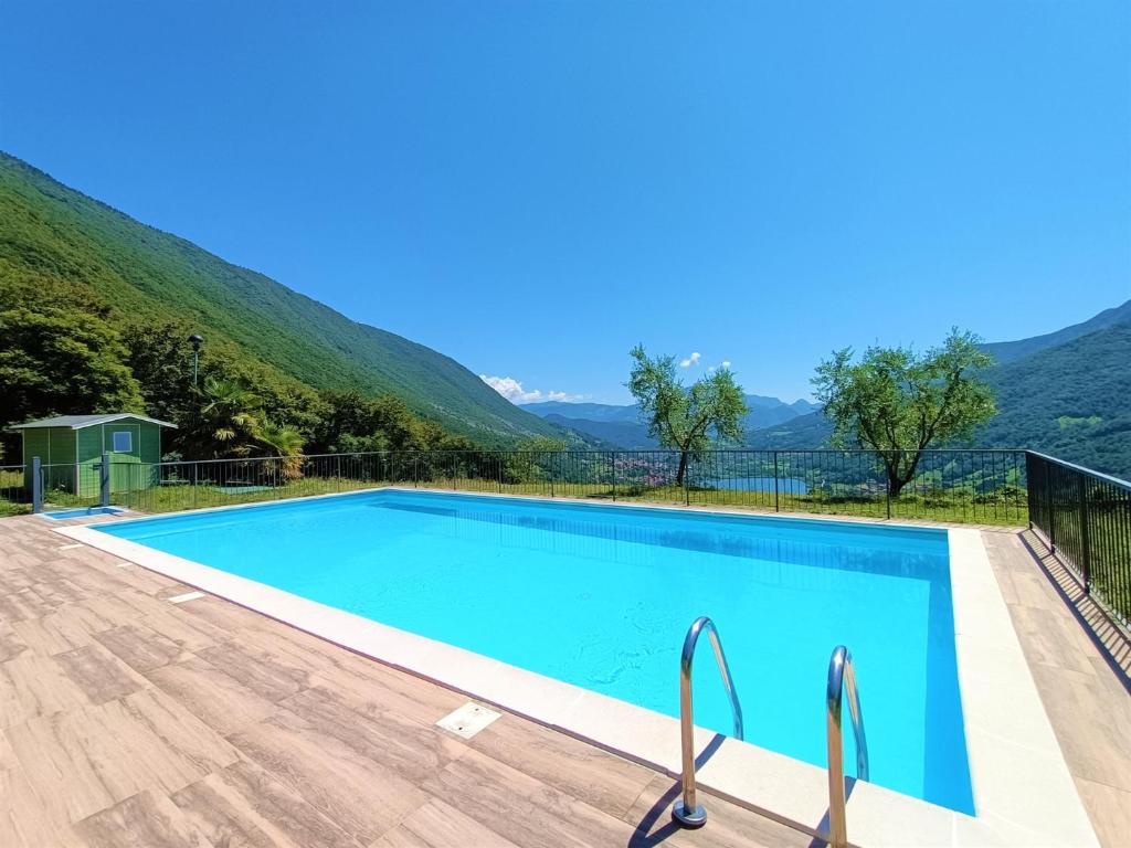 una piscina con una montaña en el fondo en IseoLakeRental - Appartamento Caterina, en Ranzanico