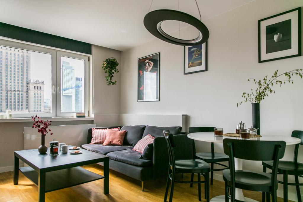 een woonkamer met een bank en een tafel bij Apartament Złota in Warschau