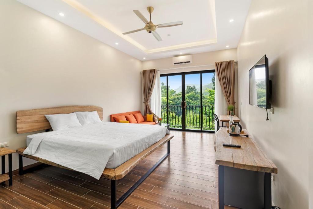 a bedroom with a bed and a tv and a couch at Cerf Volant Soc Son in Sóc Sơn