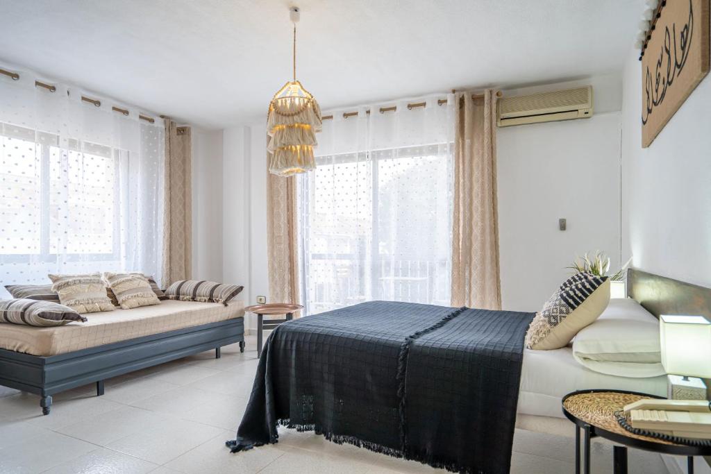 een slaapkamer met een bed, een bank en ramen bij Hotel Los Narejos in Los Alcázares