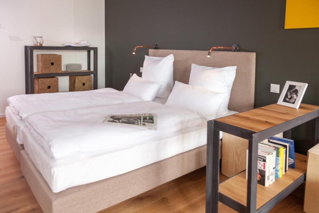 a bedroom with a large white bed with a side table at Staycity Aparthotels Dresden City Centre in Dresden