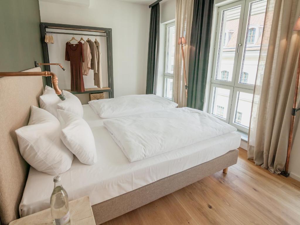 a bed with white sheets and pillows in a bedroom at Staycity Aparthotels Dresden City Centre in Dresden