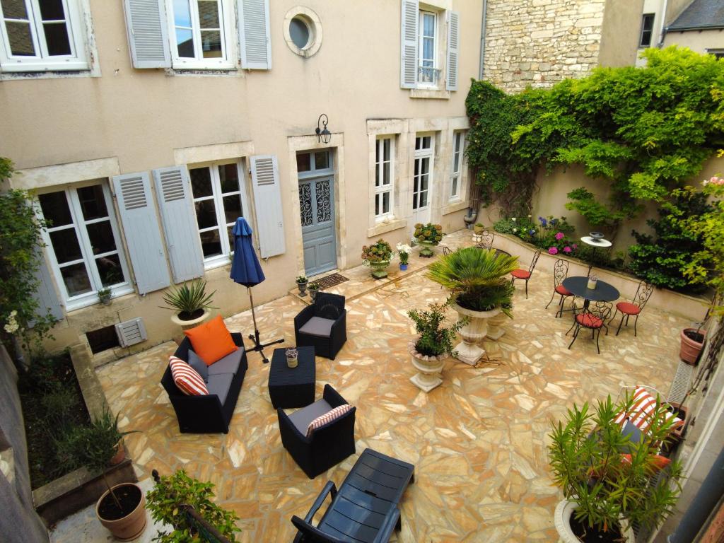 eine Terrasse mit Gartenmöbeln sowie einem Tisch und Stühlen in der Unterkunft Maison d'hôtes de charme - Au Lys Blanc in Châteauroux