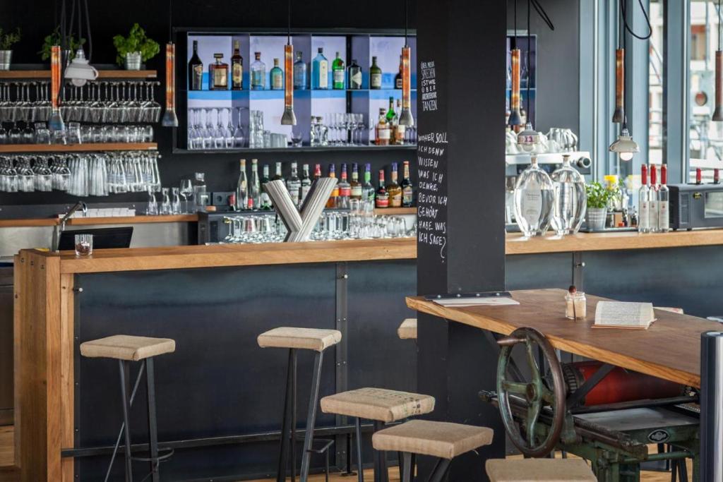 a bar at a restaurant with stools at Staycity Aparthotels Dresden City Centre in Dresden