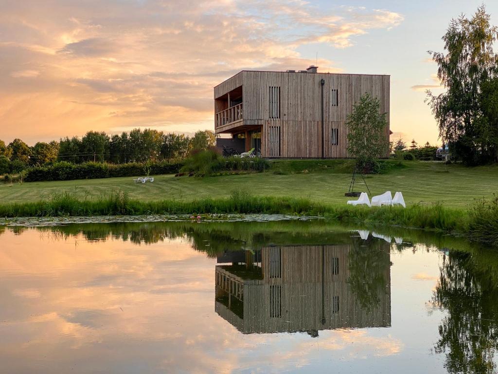 a building next to a body of water at Glemuria in Kętrzyn