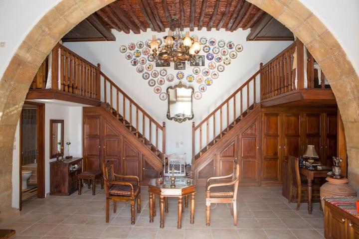 a dining room with a table and chairs and a chandelier at Matina's traditional house in Haraki