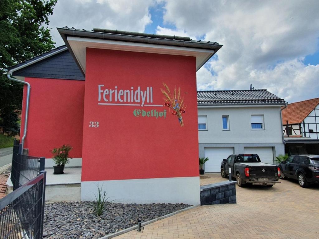 un edificio rojo con un cartel en el costado en Ferienidyll Edelhof, en Kolkwitz