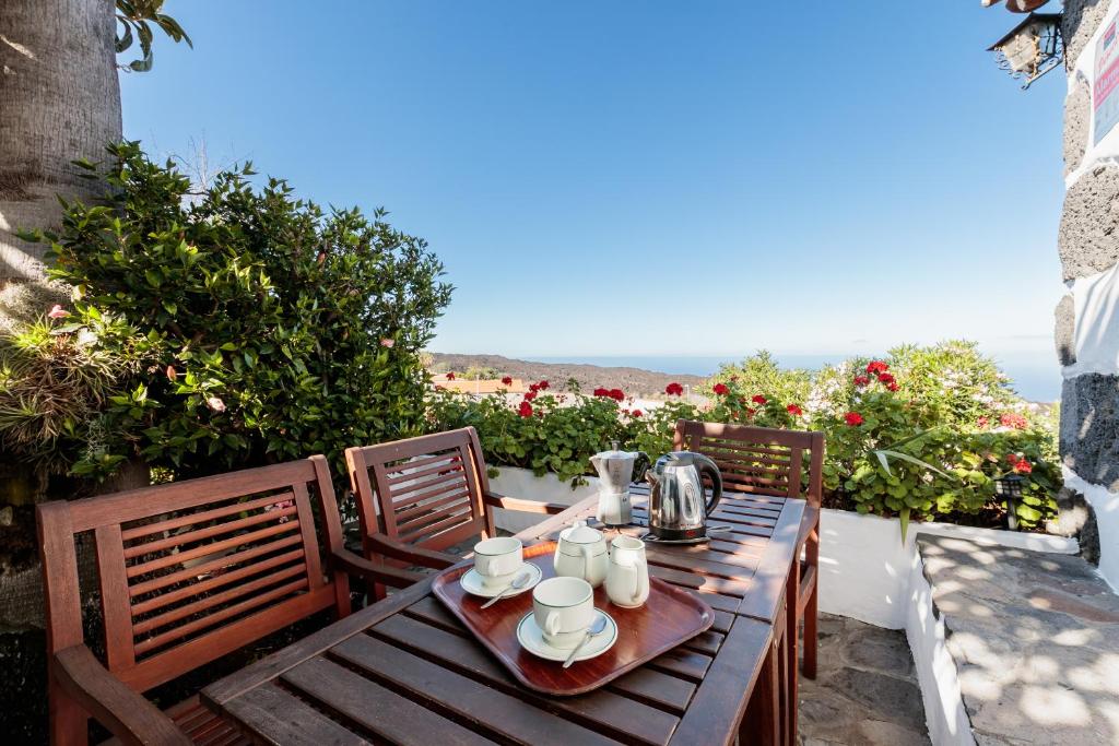 a wooden table and chairs on a balcony with the ocean at El Rincón in El Paso