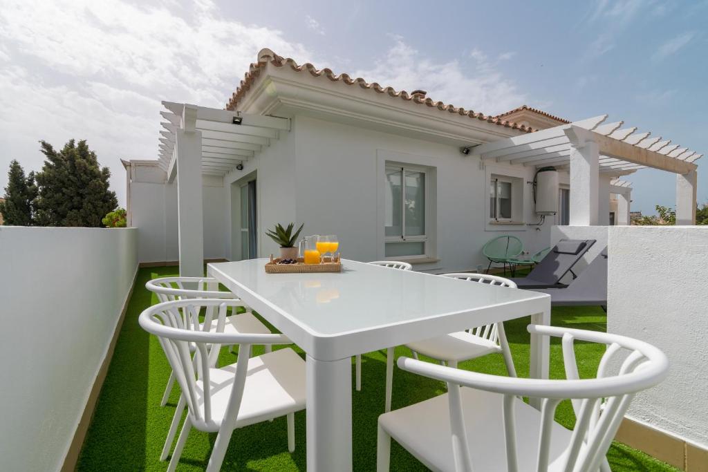 a white table and chairs in front of a house at iloftmalaga Ático Carihuela in Torremolinos